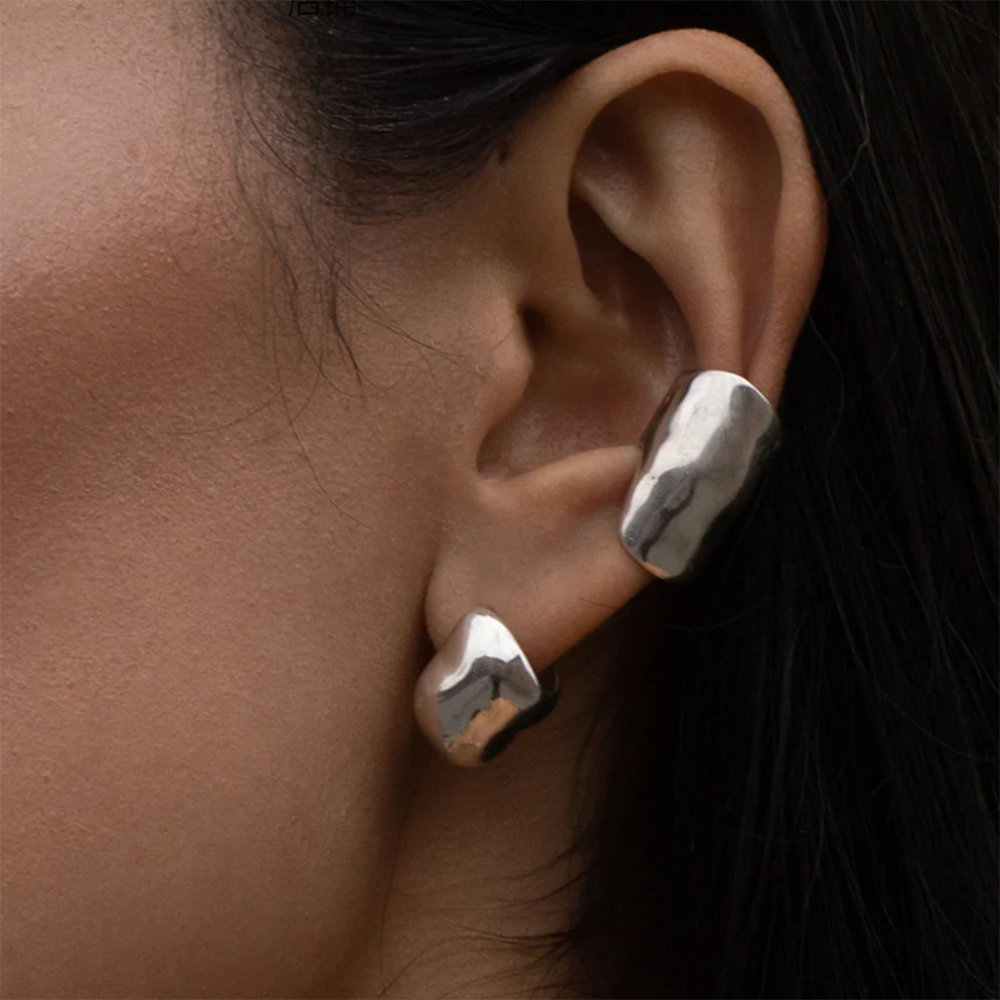 Close-up of molten-style sculpted silver ear cuff worn on the ear – no piercing required